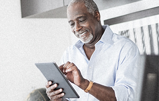 Smiling African-American man accesses information using his iPad